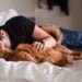 a teenager cuddling a dog in bed