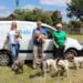 two women and a man in front of a Petpals van with dogs