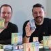 two men holding dog treat packs